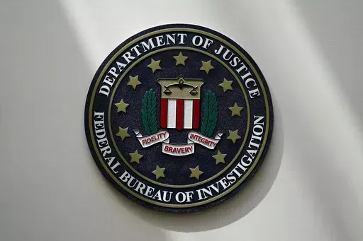 An FBI seal is seen on a wall on Aug. 10, 2022, in Omaha, Neb. The FBI says scammers stole more than $3.4 billion from older Americans last year. An FBI report released Tuesday shows a rise in losses through increasingly sophisticated tactics to trick the vulnerable into giving up their life savings. (AP Photo/Charlie Neibergall, File)