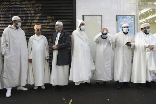 Imams from the Paris Mosque gather before paying their homage to the victims of the Nov. 13, 2015 attacks, near the Bataclan concert hall in Paris, Friday, Nov.12, 2021. The French government on Saturday, Feb. 5, 2022, forged ahead with efforts to reshape Islam in France and rid it of extremism, introducing a new body made up of clergy and laymen — and women — to help lead the largest Muslim community in western Europe. (AP Photo/Adrienne Surprenant, File)
