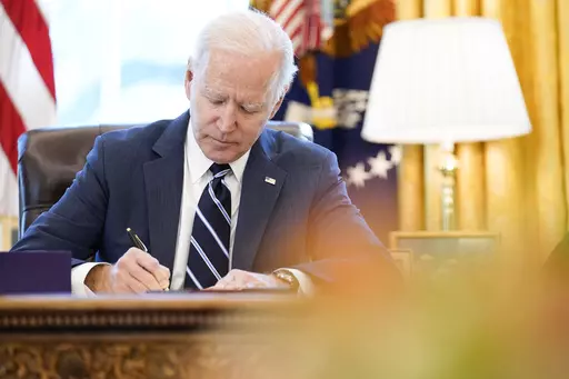 President Joe Biden signs the American Rescue Plan, a coronavirus relief package, in the Oval Office of the White House, March 11, 2021, in Washington. Federal officials estimate that local governments now have spending plans in place for most of the money they received under a prominent pandemic relief law. In some cases, it's hard to know exactly how the money is being used, because some governments haven't supplied details about their projects. (AP Photo/Andrew Harnik, File)