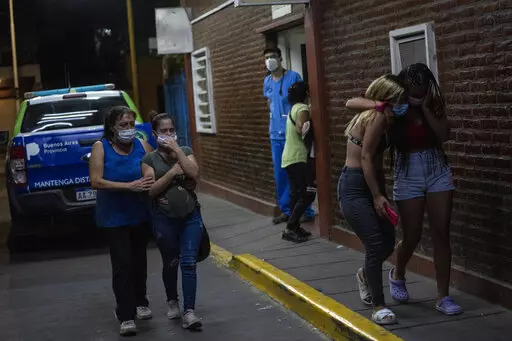 Relatives and friends of people who were poisoned with adulterated cocaine cry after talking to doctors outside the emergency room of a hospital in the outskirts of Buenos Aires, Argentina, Wednesday, Feb. 2, 2022. According to local authorities, more than a dozen people have died and at least 50 seriously sickened after consuming adulterated cocaine. (AP Photo/Rodrigo Abd)