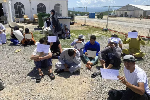 This image provided by Muhammad Arif Sarwari, shows Afghans who fled the Taliban takeover of their country staging a protest at Camp Bondsteel in Kosovo, Wednesday, June 1, 2022. The camp is used to house people who have not been allowed to enter the U.S. because of security concerns. Some of the Afghans have been waiting for months at the base while authorities try to resolve their fate, which officials say may involve sending them to another country for resettlement. (Muhammad Arif Sarwari via