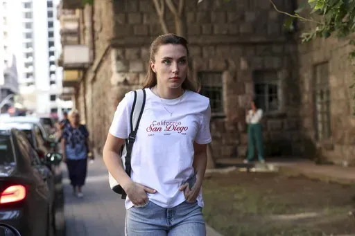 CORRECTS THE NAME OF SOURCE - Dziana Maiseyenka, 28, walks in a street in Yerevan, Armenia, Saturday, Sept. 7, 2024, after being denied entry to neighboring Georgia because an arrest warrant had been issued for her by authorities in Minsk. (Hayk Baghdasaryan/Photolure via AP)