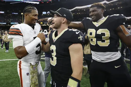 Cleveland Browns quarterback Jameis Winston (5) talks with New Orleans Saints quarterback Jake Haener (3) and tight end Juwan Johnson (83) after their NFL football game in New Orleans, Sunday, Nov. 17, 2024. (AP Photo/Butch Dill)