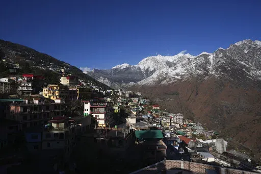 Joshimath town is seen along side snow capped mountains, in India's Himalayan mountain state of Uttarakhand, Jan. 21, 2023. For months, residents in Joshimath, a holy town burrowed high up in India's Himalayan mountains, have seen their homes slowly sink. They pleaded for help, but it never arrived. In January however, their town made national headlines. Big, deep cracks had emerged in over 860 homes, making them unlivable. (AP Photo/Rajesh Kumar Singh)