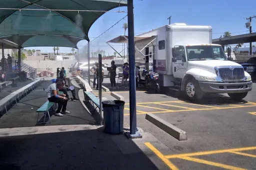 Patients gather outside one of the five Circle The City mobile clinics stationed outside a soup kitchen for homeless people, Thursday, May 30, 2024 in Phoenix. Based in the hottest big metro in America, Circle the City is taking measures to protect patients from life-threatening heat illness as temperatures hit new highs. Homeless people accounted for nearly half of the record 645 heat-related deaths last year in Arizona's Maricopa County, which encompasses metro Phoenix.(AP Photo/Matt York)
