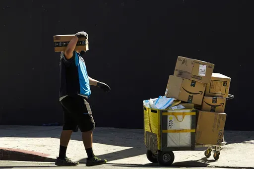An Amazon worker delivers packages in Los Angeles on Oct. 1, 2020. July sales events have become a seasonal revenue driver for the retail industry since Amazon launched its first Prime Day back in 2015. (AP Photo/Damian Dovarganes, File)
