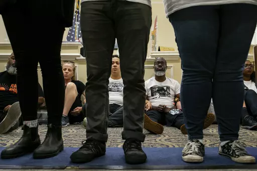 Dozens of activists stage a sit-in outside Florida Gov. Ron DeSantis' office and force people to step over them to reach DeSantis' office as they speak out against the governor and his policies, Wednesday, May 3, 2023, in Tallahassee, Fla. Florida Republicans on Wednesday approved bills to ban diversity programs in colleges and prevent students and teachers from being required to use pronouns that don't correspond to someone's sex, building on top priorities of the Republican governor. (Alicia D
