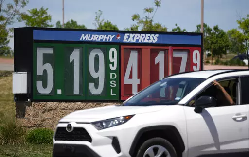 Gasoline prices are displayed outside a convenience store as a motorist drives by, Thursday, May 26, 2022, in Thornton, Colo. Experts are expecting a flush of travelers at airports and on the nation's byways during the long Memorial Day weekend, which marks the start of the summer travel season, in spite of high fuel costs. (AP Photo/David Zalubowski)