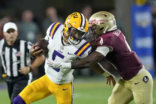 LSU quarterback Jayden Daniels, front left, tries to scramble past Florida State linebacker Kalen DeLoach (4) during the first half of an NCAA college football game Sunday, Sept. 3, 2023, in Orlando, Fla. (AP Photo/John Raoux)