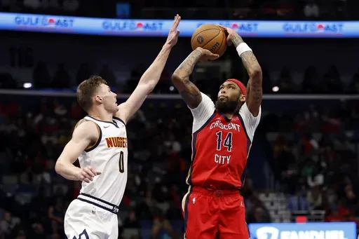 New Orleans Pelicans forward Brandon Ingram (14) shoots a basket over Denver Nuggets guard Christian Braun (0) in the first half of an NBA basketball game in New Orleans, Friday, Nov. 15, 2024. (AP Photo/Tyler Kaufman)