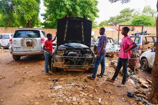 Mechanics work on a broken vehicle in Niamey, Niger, Aug. 28, 2023. Families in Niger say they are struggling in the wake of economic sanctions imposed after a military coup three months ago. Neighbouring countries in West Africa have closed their borders with Niger, stymying livestock trade. And residents in the capital, Niamey, say food prices have skyrocketed. (AP Photo/Sam Mednick,file)