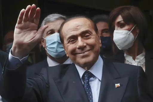 Former Italian Premier Silvio Berlusconi waves to reporters as he arrives at the Chamber of Deputies to meet Mario Draghi, in Rome, Feb. 9, 2021. Berlusconi, the boastful billionaire media mogul who was Italy's longest-serving premier despite scandals over his sex-fueled parties and allegations of corruption, died, according to Italian media. He was 86. (AP Photo/Alessandra Tarantino, File)