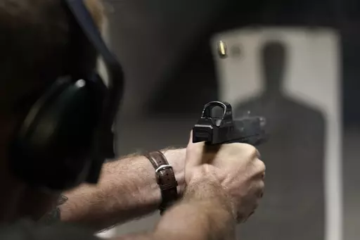 A man fires his pistol at an indoor shooting range during a qualification course to renew his Carry Concealed handgun permit at the Placer Sporting Club, July 1, 2022, in Roseville, Calif. A federal judge on Wednesday, Dec. 20, 2023, temporarily blocked a California law that would have banned carrying firearms in most public places, ruling that it violates the Second Amendment of the U.S. Constitution and deprives people of their ability to defend themselves and their loved ones. (AP Photo/Rich 