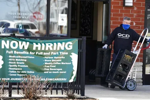 A hiring sign is displayed outside of a Starbucks in Schaumburg, Ill., Friday, April 1, 2022. America's employers added a healthy number of jobs last month, Friday, Sept. 2, yet slowed their hiring enough to potentially help the Federal Reserve in its fight to reduce raging inflation. The economy gained 315,000 jobs in August, a still-solid figure that pointed to an economy that remains resilient despite rising interest rates, high inflation and sluggish consumer spending. (AP Photo/Nam Y. Huh)