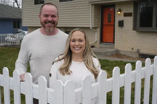 Ryan Vasko and his wife are shown outside the home they just bought after moving from Oregon, April 3, 2025, in Littleton, Colo. (AP Photo/David Zalubowski)
