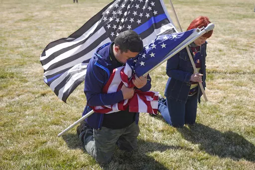 Marius Annandale kneels while praying during a Second Amendment gun rights rally at the Utah State Capitol Saturday, March 27, 2021, in Salt Lake City. After a gunman killed 19 children and two teachers at an elementary school in Uvalde, Texas, on May 24, 2022, several pastors and rabbis around the country have challenged their conservative counterparts with this question: Are you pro-life if you are pro-guns? (AP Photo/Rick Bowmer, File)