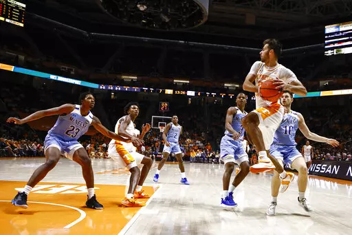 Tennessee guard Santiago Vescovi (25) passes the ball off as he's defended by McNeese State forward Roberts Berze (10) and guard Rhyjon Blackwell (3) during the first half of an NCAA college basketball game Wednesday, Nov. 30, 2022, in Knoxville, Tenn. (AP Photo/Wade Payne)