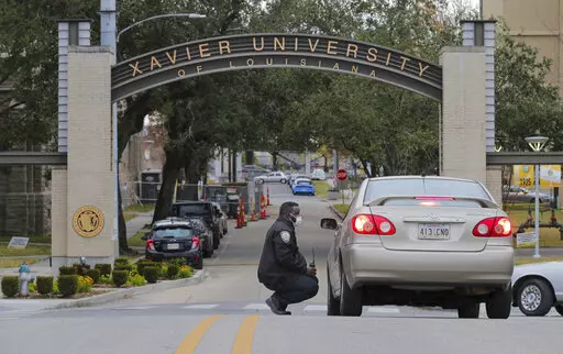 A Xavier University police officer redirects a motorist around campus after a bomb threat put the campus on lockdown in New Orleans, La., Feb. 1, 2022. As the nation’s historically Black colleges remain on edge after receiving dozens of bomb threats in recent weeks, federal law enforcement officials said they have identified six suspects who they believe are responsible for most of the racially motivated crimes. (David Grunfeld/The Advocate via AP, File)