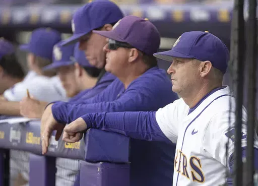 LSU head coach Jay Johnson stands in the dugout before the first pitch against Texas A&M in an NCAA college baseball game, Friday, May 3, 2024, at Alex Box Stadium in Baton Rouge, La. With two weeks left in the regular season, LSU is scrambling to avoid becoming the third straight defending national champion to miss the NCAA Tournament. (Hilary Scheinuk/The Advocate via AP, File)