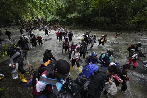 Migrants, mostly Venezuelans, cross a river during their journey through the Darien Gap from Colombia into Panama, hoping to reach the U.S., Oct. 15, 2022. The United States, Panama and Colombia announced Tuesday, April 11, 2023, that they will launch a 60-day campaign aimed at halting illegal migration through the treacherous Darien Gap, where the flow of migrants has multiplied this year. (AP Photo/Fernando Vergara, File)