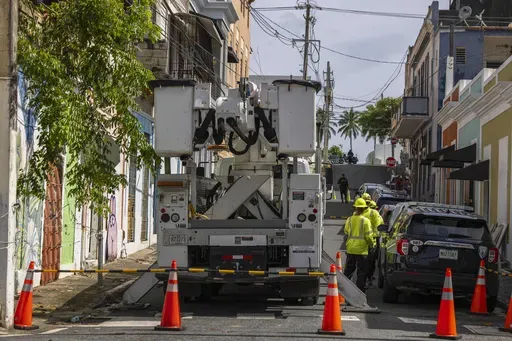 Electric workers carry out repairs in the community of Puerta de Tierra after the passage of Tropical Storm Ernesto in San Juan, Puerto Rico, Thursday, Aug. 15, 2024. (AP Photo/Alejandro Granadillo)