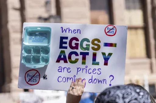 An activist holds up a sign about high egg prices during a protest against the Trump administration's policies outside the Texas Capitol, in Austin, Texas, Tuesday, March 4, 2025. (Mikala Compton/Austin American-Statesman via AP)