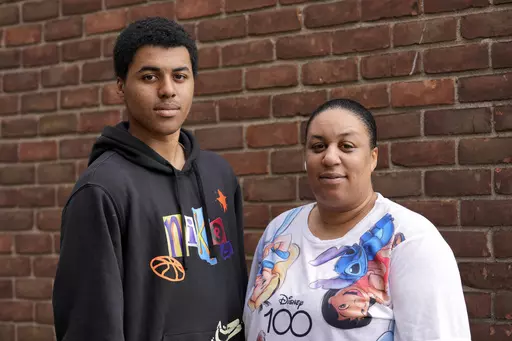 Stacy Williams stands with her son Davion, 15, in Detroit, Wednesday, Aug. 30, 2023. Davion wants to go to college. A counselor at his Detroit charter school in 2022 helped him visualize that goal, but he knows he’ll need more help to navigate the application process. So he was discouraged to learn the high school where he just began his sophomore year had laid off its college transition adviser – a staff member who provided extra help coordinating financial aid applications, transcript requ