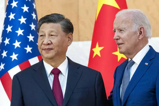 U.S. President Joe Biden, right, stands with Chinese President Xi Jinping before a meeting on the sidelines of the G20 summit meeting on Nov. 14, 2022, in Bali, Indonesia. Xi accused Washington on Monday, March 6, 2023, of trying to isolate his country and hold back its development. That reflects the ruling Communist Party's growing frustration that its pursuit of prosperity and global influence is threatened by U.S. restrictions on access to technology, its support for Taiwan and other moves se