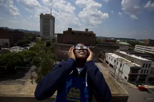 Justin Coleman, of Birmingham, Ala., holds his glasses up to his eyes as he watches the solar eclipse atop a parking structure, Monday, Aug. 21, 2017, in Birmingham. Safe solar eclipse glasses block out the sun’s ultraviolet rays and nearly all visible light. When worn indoors, only very bright lights should be faintly visible – not household furniture or wallpaper. (AP Photo/Brynn Anderson, File)