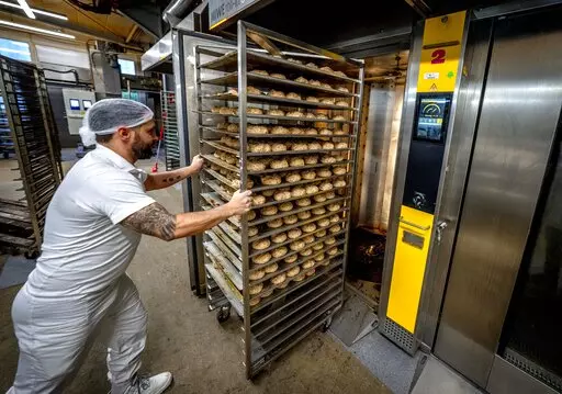 ADDING FULL NAME OF BUSINESS  An employee pushes bread rolls into one of the gas heated ovens in the producing facility in Cafe Ernst in Neu Isenburg, Germany, Monday, Sept. 19, 2022. Andreas Schmitt, head of the local bakers' guild, said some small bakeries are contemplating giving up due to the energy crisis. (AP Photo/Michael Probst)
