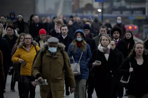 Workers walk over London Bridge towards the City of London financial district during the morning rush hour, in London, Monday, Jan. 24, 2022. For many in the U.K., the pandemic may as well be over. Mask requirements have been dropped everywhere and free mass testing is a thing of the past. The sense of freedom is widespread even as infections soared to record levels in Britain in March, driven by the milder but more transmissible Omicron BA.2 variant that’s rapidly spreading around Europe, the