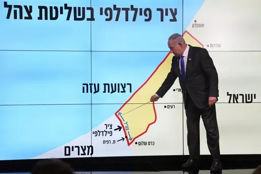 Israeli Prime Minister Benjamin Netanyahu stands before a map of the Gaza Strip, telling viewers that Israel must retain control over the "Philadelphi corridor," a strategic area along the territory's border with Egypt, during a news conference in Jerusalem, Monday, Sept. 2, 2024. The Hebrew on the screen reads, "Philadelphi corridor under Israeli military control." (AP Photo/Ohad Zwigenberg, Pool)