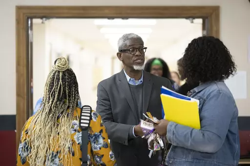 William Penn School District Superintendent Eric Becoats, center, speaks with prospective applicants during a teachers job fair at the high school's cafeteria in Lansdowne, Pa., Wednesday, May 3, 2023. As schools across the country struggle to find teachers to hire, more governors are pushing for pay increases and bonuses for the beleaguered profession. (AP Photo/Matt Rourke)