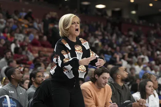 LSU head coach Kim Mulkey makes a traveling gesture during an NCAA college basketball against Florida game in the quarterfinals of the Southeastern Conference tournament, Friday, March 7, 2025, in Greenville, S.C. (AP Photo/David Yeazell)