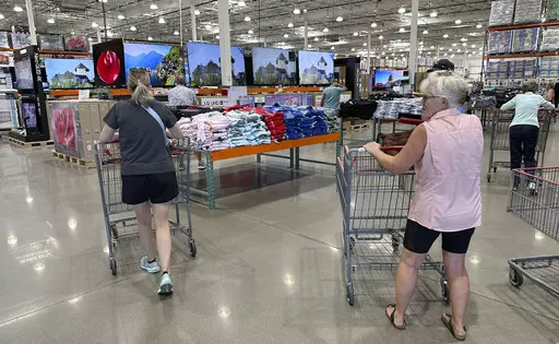 Shoppers push carts into a Costco warehouse Friday, Aug. 4, 2023, in Thornton, Colo. A surge in U.S. consumer spending is fueling economic growth, reflecting a resilience among households that has confounded economists, Federal Reserve officials and even the sentiments that Americans themselves have expressed in surveys.(AP Photo/David Zalubowski, File)