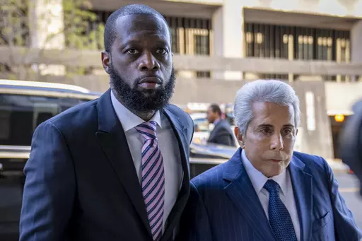 Prakazrel "Pras" Michel, left, a member of the 1990s hip-hop group the Fugees, accompanied by defense lawyer David Kenner, right, arrives at federal court for his trial in an alleged campaign finance conspiracy, Thursday, March 30, 2023, in Washington. Michel, who was accused in multimillion-dollar political conspiracies spanning two presidencies, was convicted Wednesday, April 26, after a trial that included testimony ranging from actor Leonardo DiCaprio to former U.S. Attorney General Jeff Ses