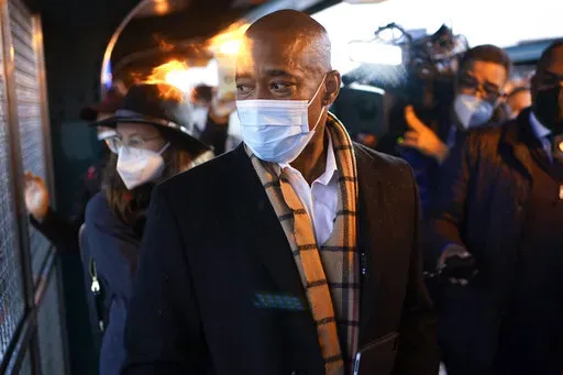 New York City Mayor Eric Adams looks at a fight on the street while waiting for the subway to City Hall on his first day in office in New York, Saturday, Jan. 1, 2022. Adams called the police to report an assault in progress. (AP Photo/Seth Wenig)