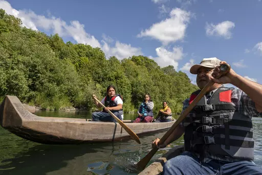 Yurok tribal members lead a redwood canoe tour on the lower Klamath River on Tuesday, June 8, 2021, in Klamath, Calif. California officials and tribal leaders announced the Visit Native California initiative to drive up tourism in Native communities, Wednesday, Sept. 14, 2022. The canoe tours, in traditionally-made canoes, are among the many cultural experiences visitors can find throughout the state. (AP Photo/Nathan Howard, File)