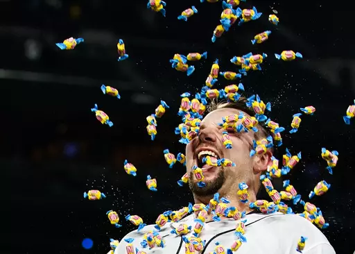 Seattle Mariners' Cal Raleigh smiles as a teammate throws pieces of bubble gum at him during an interview after Raleigh hit a single to drive in the winning run against the New York Yankees during the 10th inning of a baseball game in Seattle, Wednesday, May 31, 2023. (AP Photo/Lindsey Wasson)
