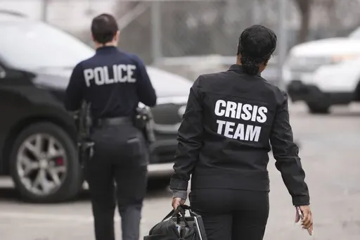 Crisis Intervention Response Team (CIRT) members Therapist Krystian Gardner, right, and Philadelphia Police Officer Vanity Cordero move to their vehicle near the start of their shift in Philadelphia, Friday, March 14, 2025. (AP Photo/Matt Rourke)