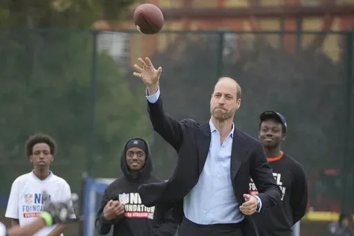 Britain's Prince William throws a football as he attends a NFL Foundation NFL Flag event, an inclusive and fast paced American Football format, in London, Tuesday, Oct. 15, 2024. (AP Photo/Kin Cheung, Pool)