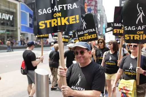 Actor Jason Kravits carries a sign on a picket line outside Paramount in Times Square in New York on July 17, 2023. (Photo by Charles Sykes/Invision/AP)