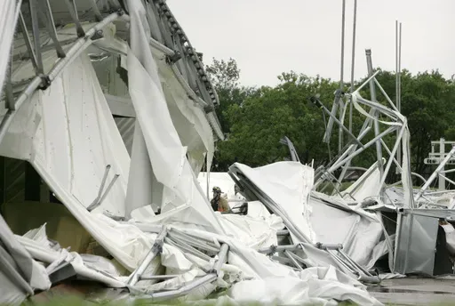 A fire fighter, center, stands surrounded by the collapsed canopy that covered the Dallas Cowboys indoor practice facility in Irving, Texas, on May 2, 2009. (AP Photo/Tony Gutierrez, File)