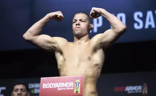 FILE -FILE - Welterweight fighter Nate Diaz poses on the scale during a ceremonial weigh-in for the UFC 279 mixed martial arts event on Sept. 9, 2022, in Las Vegas. Mixed martial arts fighter Nate Diaz turned himself in to police in New Orleans on Thursday, April 27, 2023, to face a battery charge arising from a weekend street brawl. (Steve Marcus/Las Vegas Sun via AP, File)