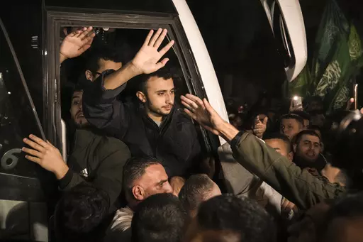 Men wave after being released from prison by Israel, Thursday, Nov. 30, 2023, in the West Bank town of Ramallah. (AP Photo/Nasser Nasser, File)