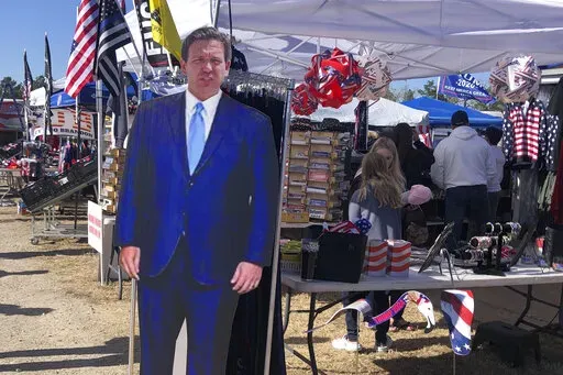 A cardboard cutout of Florida Gov. Ron DeSantis stands in the merchandise area outside former President Donald Trump's rally in Conroe, Texas, Saturday, Jan. 29, 2022. At Trump’s rally, there were signs of change. Next to the Trump hats, shirts and flags sat a collection of Ron “DeSantis 2024” bumper stickers. The vast majority of those interviewed at Trump’s rally enthusiastically cheered the prospect of another Trump run. But there were some who conceded that, perhaps, there might be a