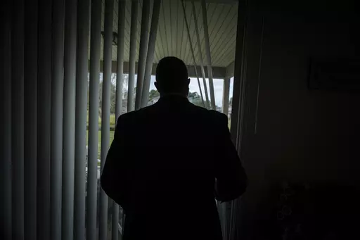 Joseph Moore looks out of a window at his home in Jacksonville, Fla., on Tuesday, Dec. 7, 2021. Moore worked for nearly 10 years as an undercover informant for the FBI, infiltrating the Ku Klux Klan in Florida, foiling at least two murder plots, according to investigators, and investigating ties between law enforcement and the white supremacist organization. "From where I sat, with the intelligence laid out, I can tell you that none of these agencies have any control over any of it. It is more p