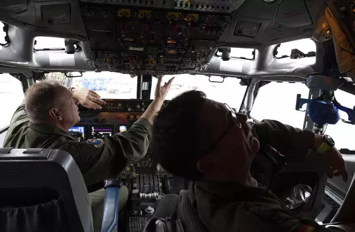 Pilots work in the cockpit of an AWACS plane at Melsbroek military airport in Melsbroek, Belgium, Wednesday, Nov. 27, 2019. As Russia’s military buildup near Ukraine accelerated early this year, military planners at NATO began preparing to dispatch scores of fighter jets and surveillance aircraft into the skies near Russia and Ukraine. It was a warning to Moscow not to make the mistake of targeting any member country. (AP Photo/Virginia Mayo, File)