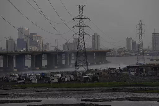 High tension power lines pass through Makoko slum in Lagos, Nigeria, Saturday, Aug. 20, 2022. From Zimbabwe, where many must work at night because i t's the only time there is power, to Nigeria where collapses of the grid are frequent, the reliable supply of electricity remains elusive across Africa. (AP Photo/Sunday Alamba/File)
