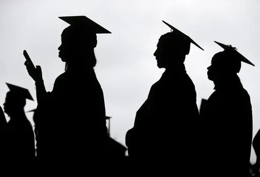 New graduates line up before the start of a community college commencement in East Rutherford, N.J., on May 17, 2018. President Joe Biden is expected to announce Wednesday Aug. 24, 2022 that many Americans can have up to $10,000 in federal student loan debt forgiven. (AP Photo/Seth Wenig, File)
